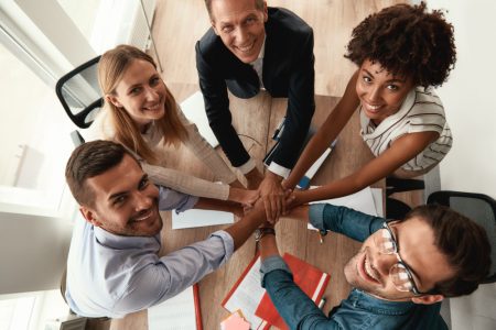 5top-view-business-people-holding-hands-together-looking-camera-with-smile-while