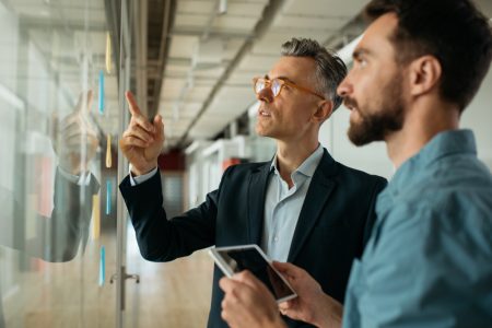 9scrum-master-using-sticky-notes-standing-near-planning-board-office